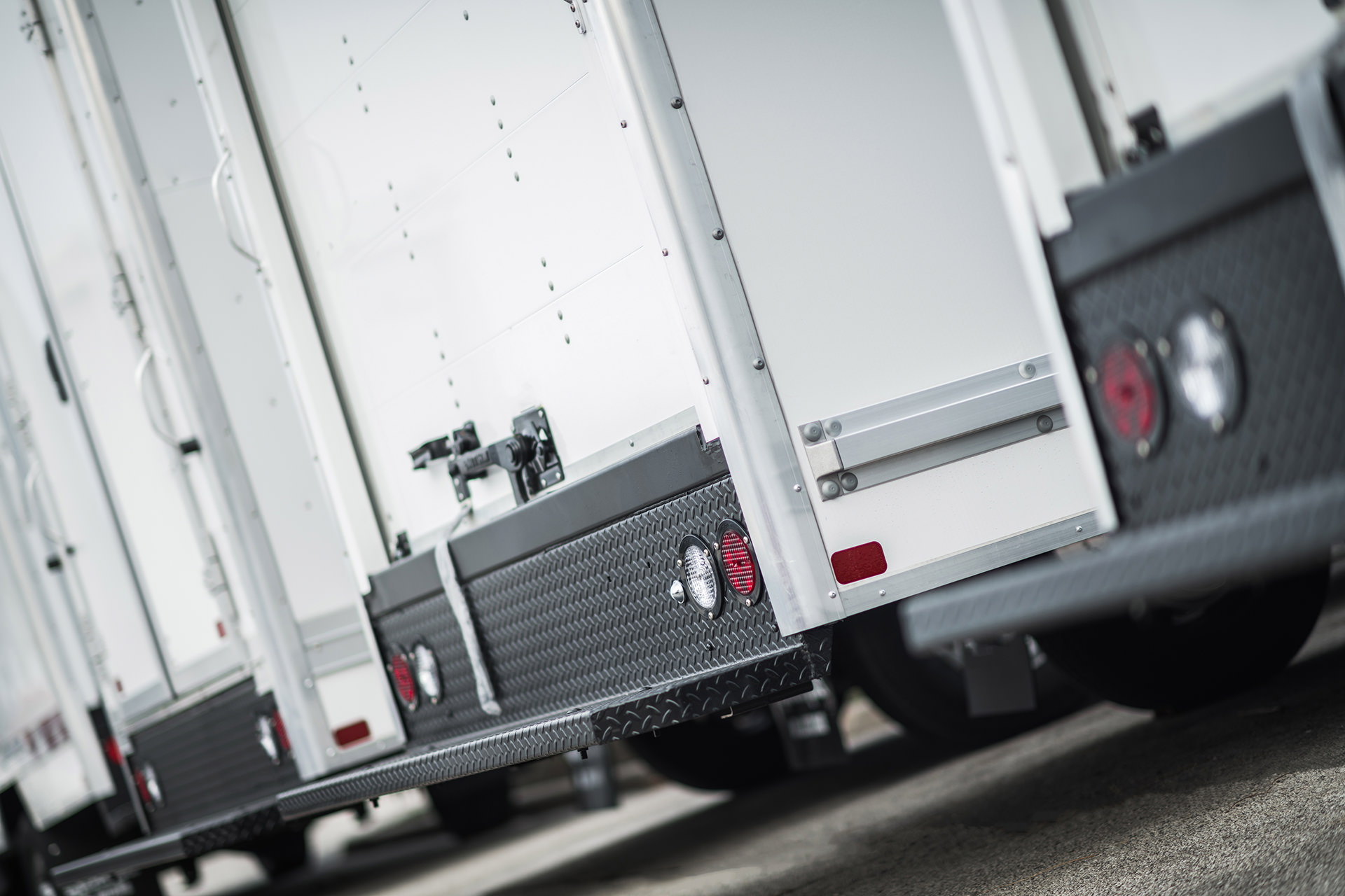 Multiple enclosed trailers parked together in a commercial lot.